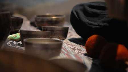 A young Asian guy playing Tibedt singing copper cups on a viewing mountain in natureの写真素材