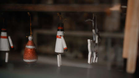 Little white Christmas toys deer soldier hanging on a thread behind glass in the house