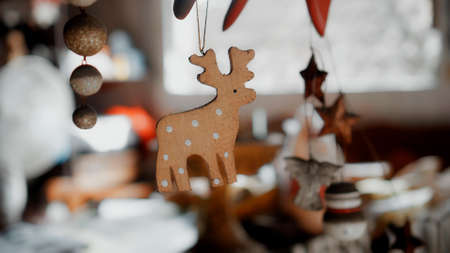 Little wooden Christmas toys deer hanging on a thread in the houseの写真素材