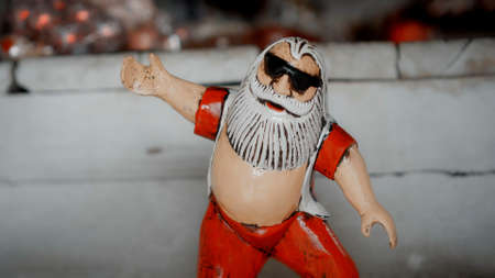 Small Christmas wooden toys of santa claus stay on a surfboard in the house