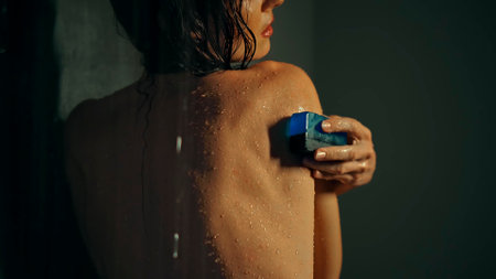 Young European girl long-haired brunette lies in the bathroom with red flowers on spa procedureの写真素材
