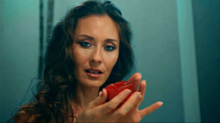 Young European girl long-haired brunette lies in the bathroom with red flowers on spa procedureの写真素材