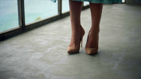 The legs of a young and beautiful European girl walking in the room