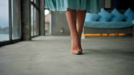 The legs of a young and beautiful European girl walking in the roomの写真素材