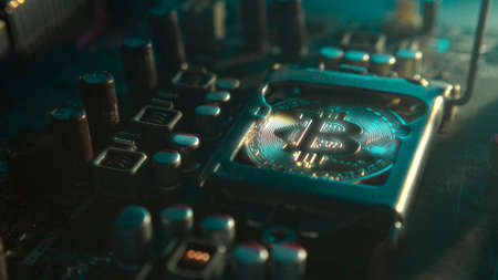 A gold Bitcoin coin with glare and reflection installed instead of a central processor in the...
