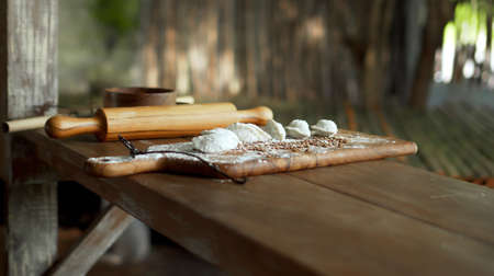 Traditional rustic Russian fresh handmade dumplings lying on the wooden table on the cutting boardの写真素材