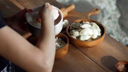 Traditional Russian fresh handmade dumplings lying on a wooden table on a cutting board with cottage...