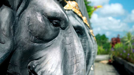 Statues of elephants in hats holding a concrete slab on their backsの写真素材