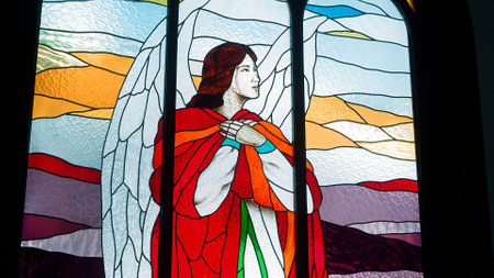 Windows in the Catholic Church with multicolored mosaic glass and bright lights at the backのeditorial素材
