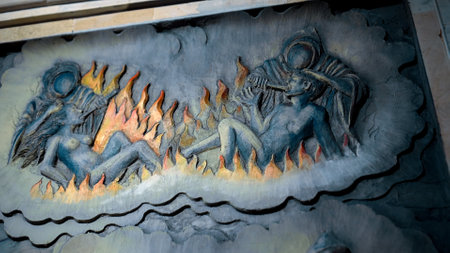 Kintamali, Bali, Indonesia - 05, July 2022: A painting on a wall in a Buddhist temple depicting hell. Torment of sinners. Servants of hell burn souls with fire in hell.のeditorial素材