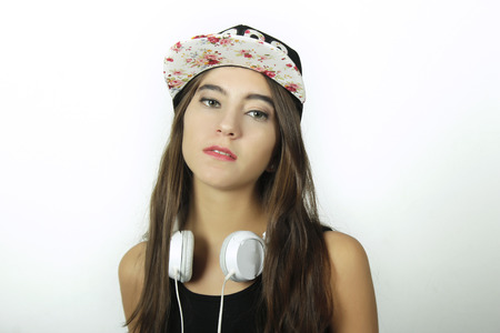 Trendy and stylish young girl listening to music with white headphones.の写真素材
