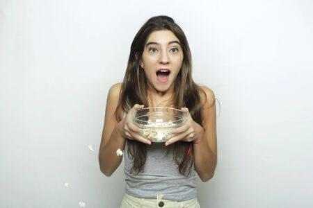 Attractive young woman watching a movie with popcornの写真素材