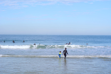 People surfing in a tropical beach on a sunny day.の写真素材