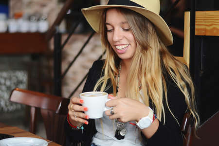 Portrait of young beautiful woman drinking coffe in a urban cafe.の写真素材