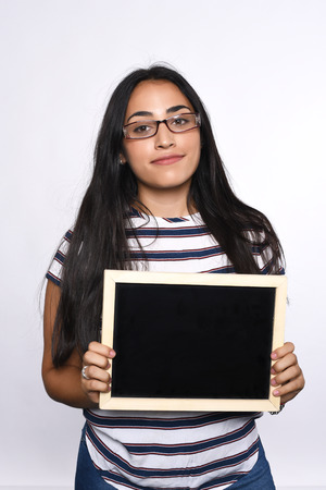 Portrait of latin woman holding chalkboard. Isolated white background.の写真素材