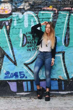 Young beautiful women posing against colorful wall outdoors.の写真素材