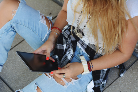 Young woman using her tablet outdoorsの写真素材