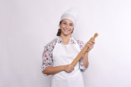 young woman chef with rolling pin. Isolated on white background.の写真素材