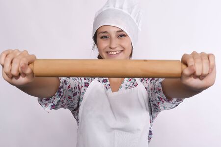 Close up of young beautiful chef with a rolling pin. Isolated white background.の写真素材