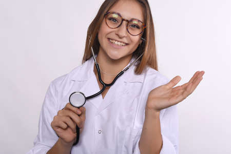 Portrait of a beautiful doctor with a stethoscope. Isolated white background.の写真素材