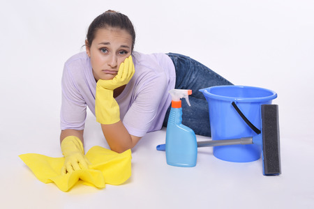 Portrait of young beautiful woman tired of cleaning up. Isolated white background.の写真素材