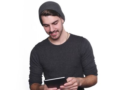 Portrait of young handsome man using tablet. Isolated white background.の写真素材