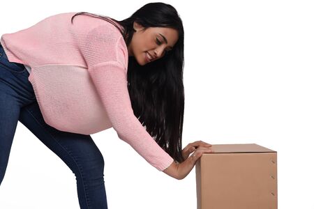 Young beautiful woman opening a box. Isolated white background.の写真素材