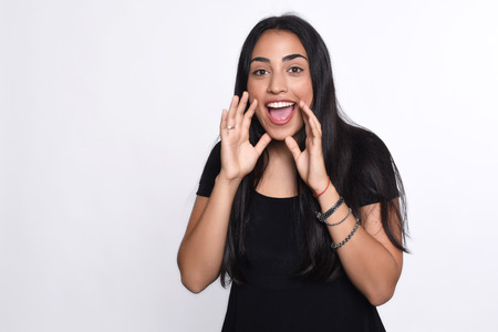 Beautiful young woman shouting and screaming. Isolated white background.の写真素材
