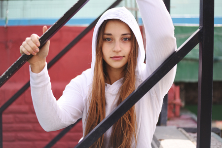 Portrait of an attractive young woman with sport clothes sitting at stairs.の写真素材