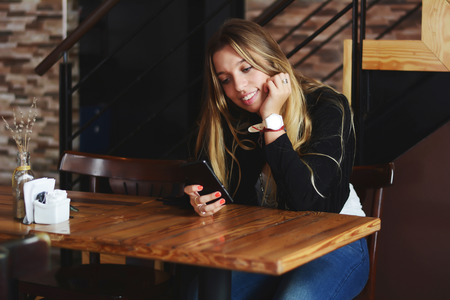 Young beautiful woman using her smartphone in to Urban Cafe