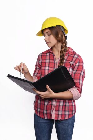 Portrait of beautiful woman construction worker reading blueprints. Isolated white background.の写真素材