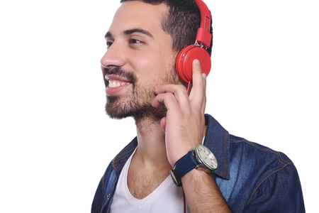 Portrait of young latin man listening to music. Isolated white background.の写真素材