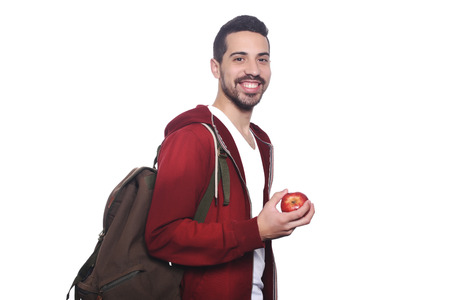 Portrait of young latin student with an apple and backpack. Isolated white background.の写真素材