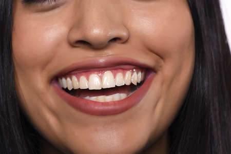 Close up of young beautiful woman with white healthy teeth smiling.の写真素材