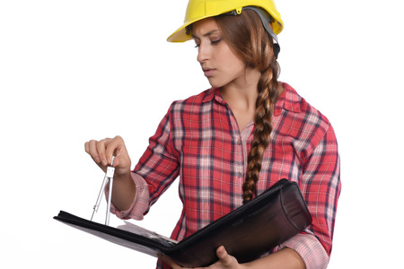 Portrait of beautiful woman construction worker reading blueprints and with a compass. Isolated...
