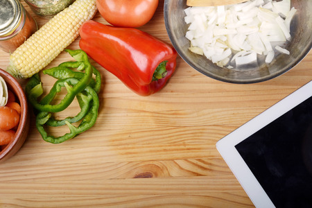 Vegetables with a digital tablet pc on wooden table. Healthy food concept.の写真素材