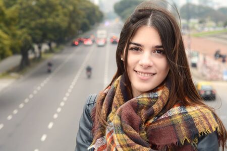 Portrait of a young beautiful woman outdoors. Urban scene.