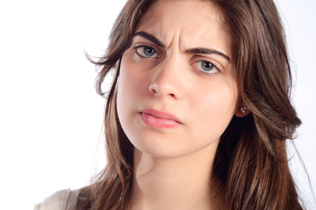 Portrait of young serious and angry woman. Isolated white background.