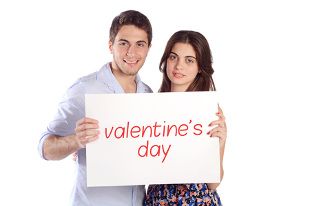 Portrait of a young beautiful couple holding cardboard with word "Valentine day". Isolated white background.の写真素材