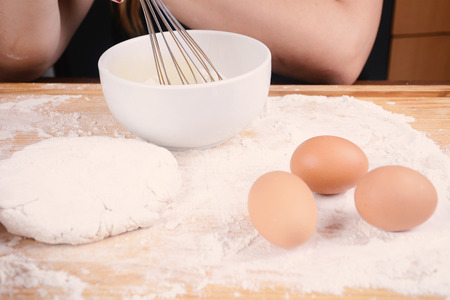 Close up of dough, eggs and a bowl. Cooking concept.