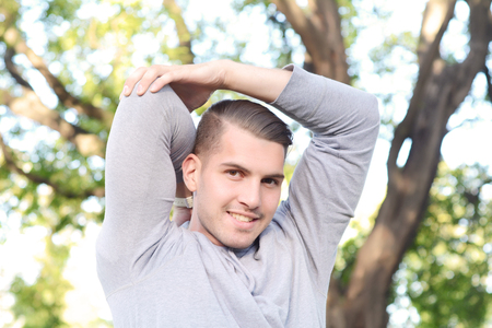 Portrait of a young handsome man doing exercises at the park. healthy concept. Outdoors.