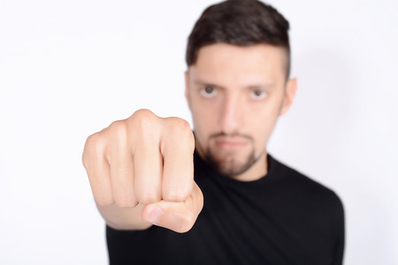 Portrait of a young man punching to the front. Isolated white background.の写真素材