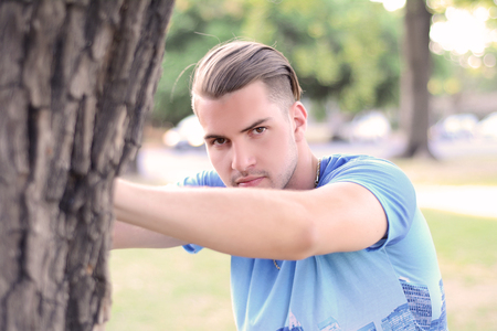 Portrait of a young handsome man doing exercises at the park. healthy concept. Outdoors.の写真素材