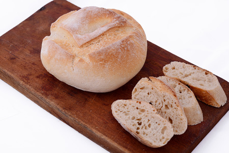Close up of fresh bread with bread slices. Isolated white background