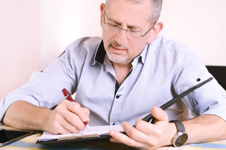 Close-up of businessman signing a document. Indoors