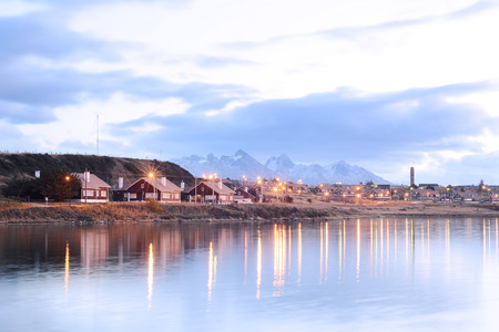 A village on the river at the sunset with mountains at back.の写真素材