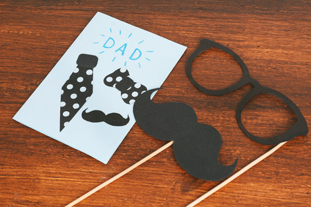 Happy FatherÂ´s Day greeting card with Photo booth props glasses and mustache on wooden backgroundの写真素材