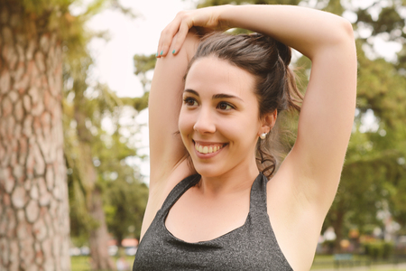 Portrair of young beautiful woman doing exercise at park. Sport concept. Outdoorsの写真素材
