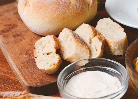 Top view of bread with dip of cream cheese on wooden table