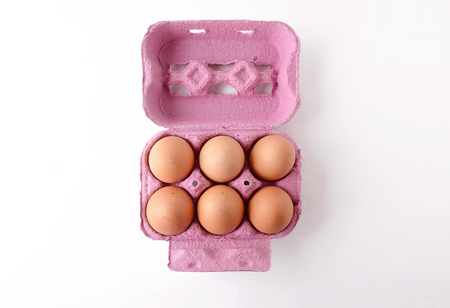 Top view of six brown eggs on box. Fresh food concept. White background